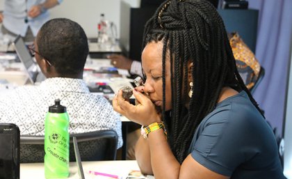 A visiting student from Africa examines a gem stone.